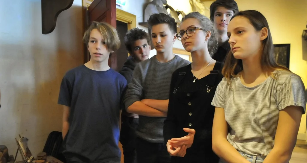 Een foto van een groep kinderen die naar iets kijken.