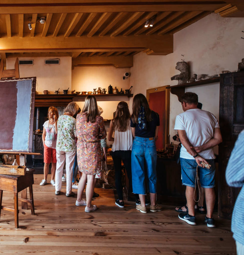 Bezoekers van het museum staan in een ruimte te luisteren naar een specialist van Rembrandthuis